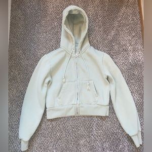 A light green Brandy Melville cropped top zip up.